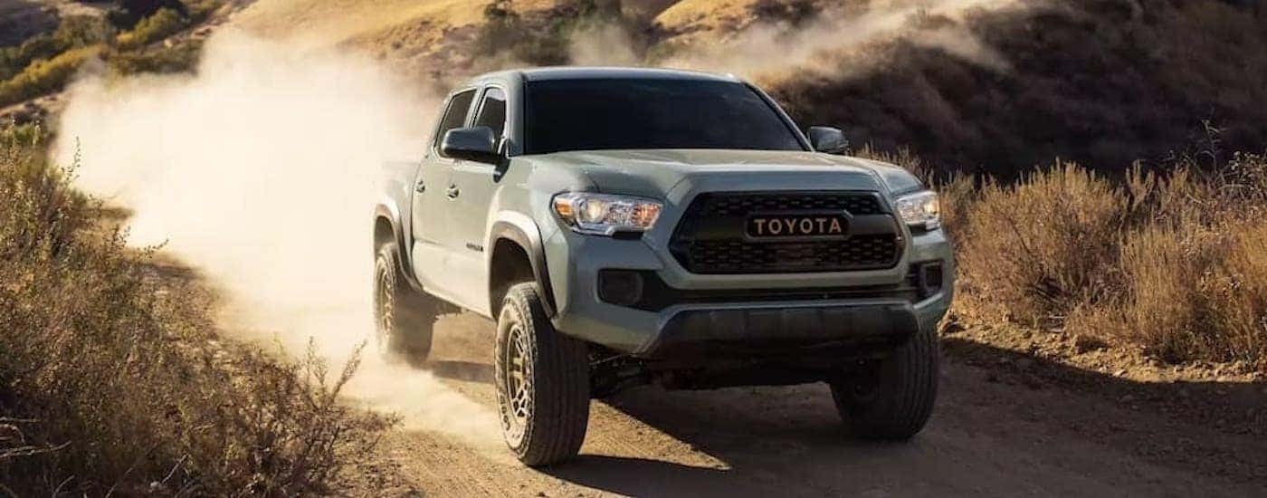 A grey 2022 Toyota Tacoma Trail is shown from the front at an angle after leaving a truck dealer.