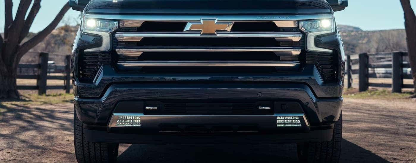 The grille on a 2024 Chevy Silverado 1500 High Country parked on a farm.