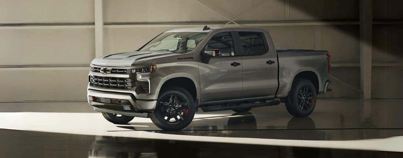 A silver 2024 Chevy Silverado 1500 Redline is shown from the side parked in a warehouse.