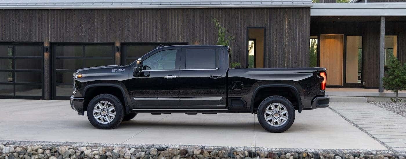 A black 2024 Chevy Silverado 2500 HD High Country is shown from the side.