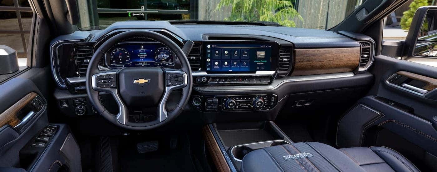 The black and woodgrain interior of a 2024 Chevy Silverado 2500 High Country