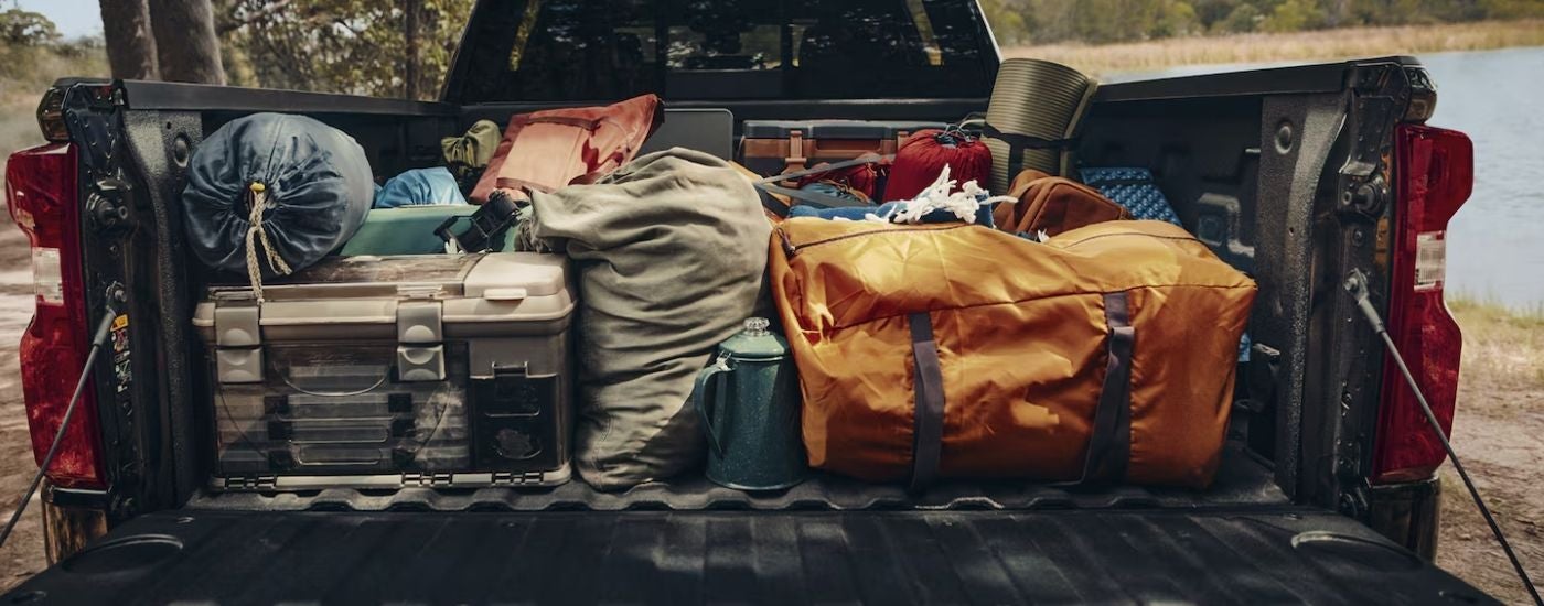 Camping gear in the bed of a red 2026 Chevy Silverado 1500 RST