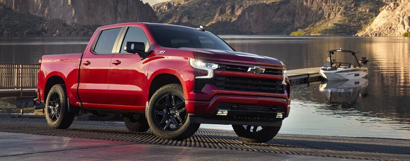 Red 2026 Chevy Silverado 1500 RST parked on a ramp by a lake