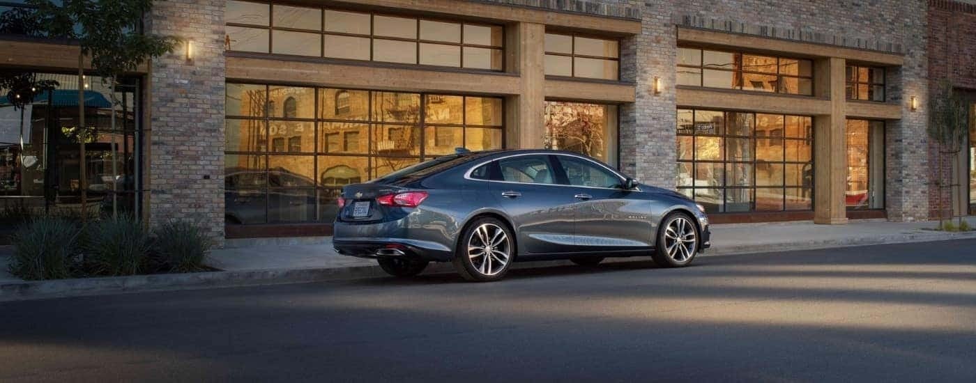 A grey 2021 Chevy Malibu is shown from the side after leaving a used car dealer.