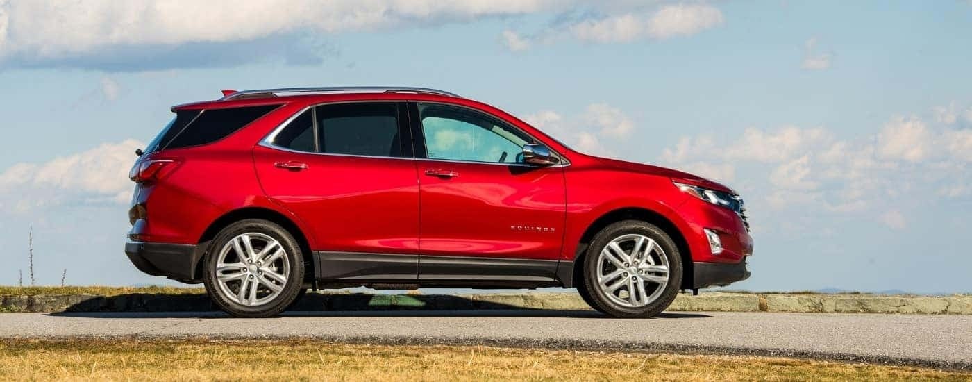 A red 2018 Chevy Equinox is shown from the side after leaving a used car dealer near Bessemer.