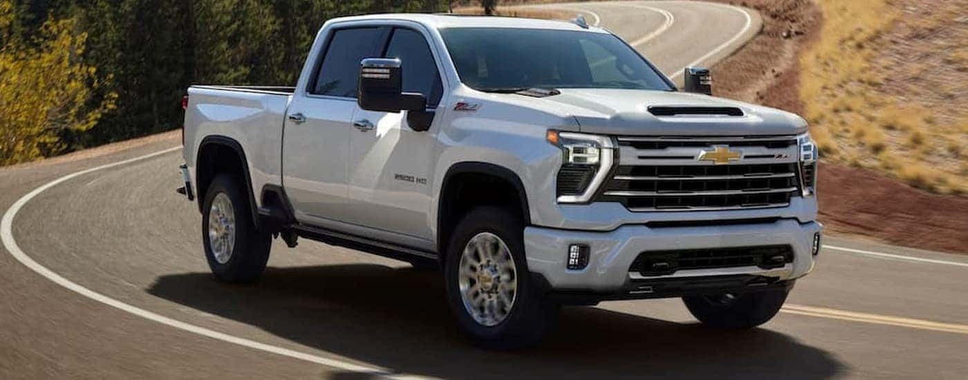 A white 2026 Chevy Silverado 2500 HD driving down a road